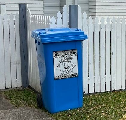Blondies Bin garden bin by white fence